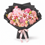 Blush Spectacle, pink orchids, pink and white lilies, blush roses, hydrangea and carnations in black wrapping