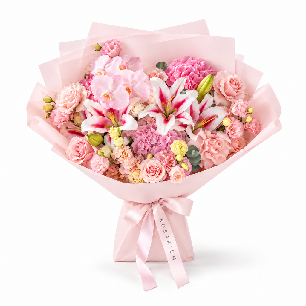 Blush Spectacle, pink orchids, pink and white lilies, blush roses, hydrangea and carnations in light pink wrapping