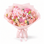 Blush Spectacle, pink orchids, pink and white lilies, blush roses, hydrangea and carnations in light pink wrapping
