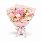 Coral Spark, cream and coral roses, pink hydrangea, carnations and cream lisianthus in light pink wrapping