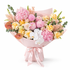 Marina in Colour, yellow roses, pink chrysanthemums, white orchids, hydrangea and lisianthus in light pink wrapping