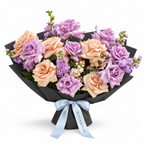 Ocean Hush, soft-purple and taupe roses with seasonal pastel blooms in black wrapping