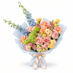 Spring with a Twist, blue delphinium, peach roses, yellow spray roses and blush carnations in blue wrapping
