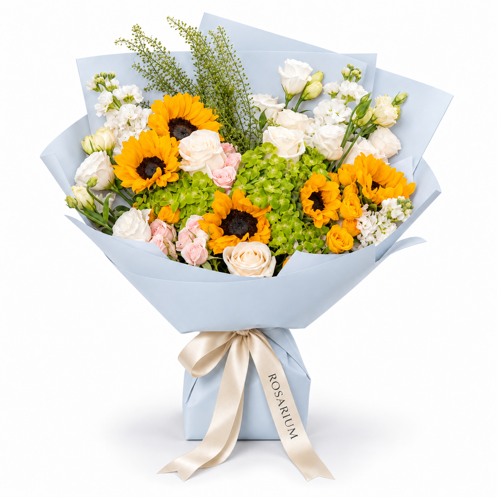 Sunshine Chorus, sunflowers, green hydrangea, pink and yellow spray roses and white stock in blue wrapping