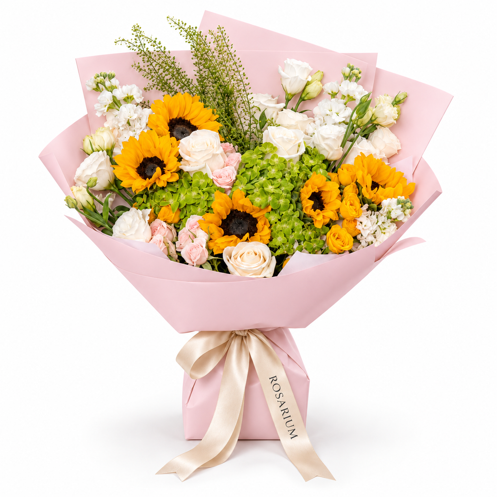 Sunshine Chorus, sunflowers, green hydrangea, pink and yellow spray roses and white stock in light pink wrapping
