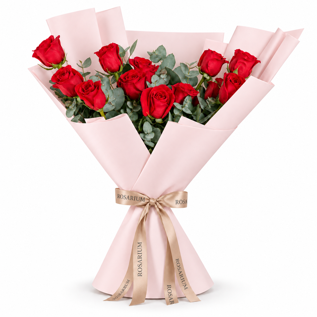 12 red roses in light pink wrapping with a Rosarium ribbon