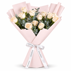 12 white roses in light pink wrapping with a Rosarium ribbon