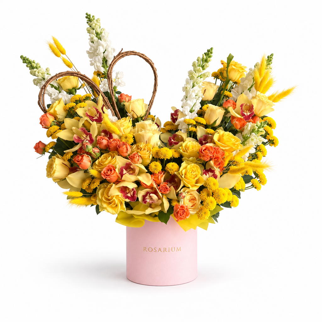 Apricot Afterglow: yellow and orange roses, yellow flowers and a woven heart in a light pink Rosarium flower box