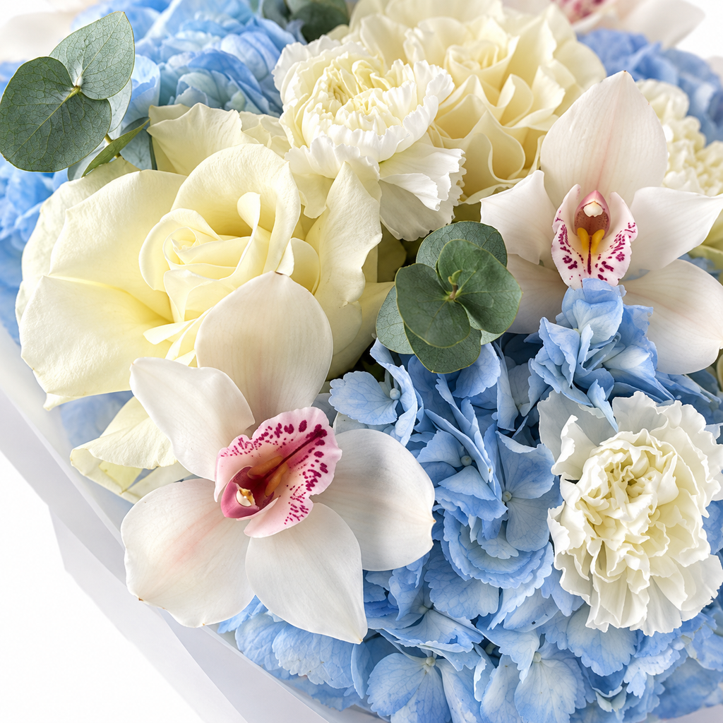 Blue Mood: close-up of ivory roses, white orchids and blue hydrangea