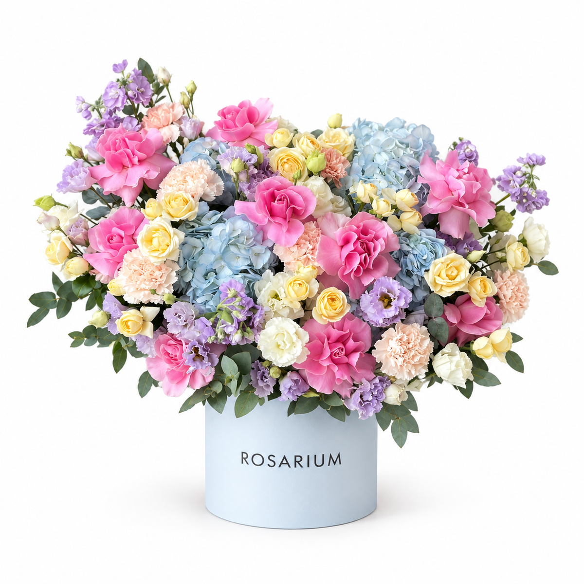 Pastel Carousel — Blue hydrangea, open pink roses and yellow spray roses with lilac stock, carnations and eucalyptus in a powder-blue box