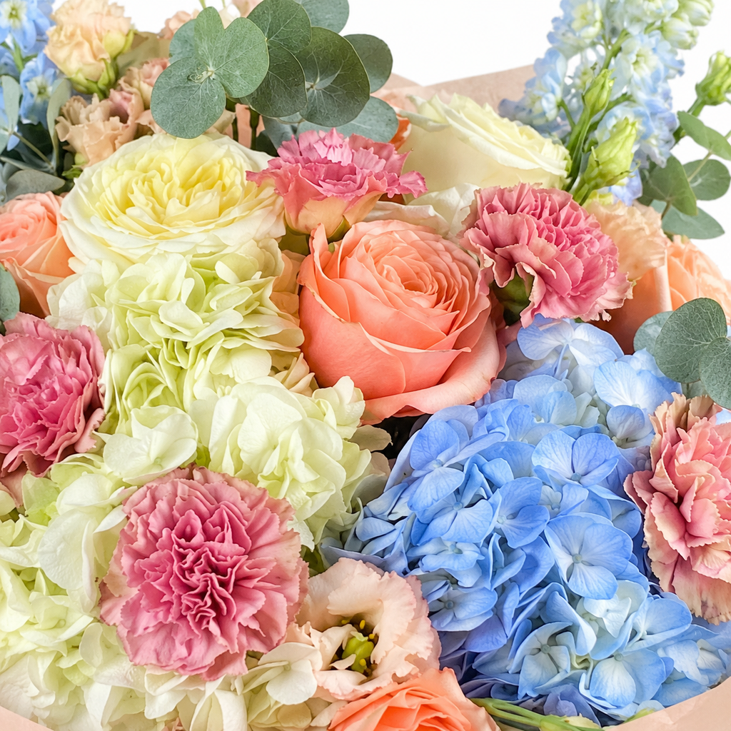 Spring with a Twist: close-up of blue and white hydrangea, peach roses and pink carnations