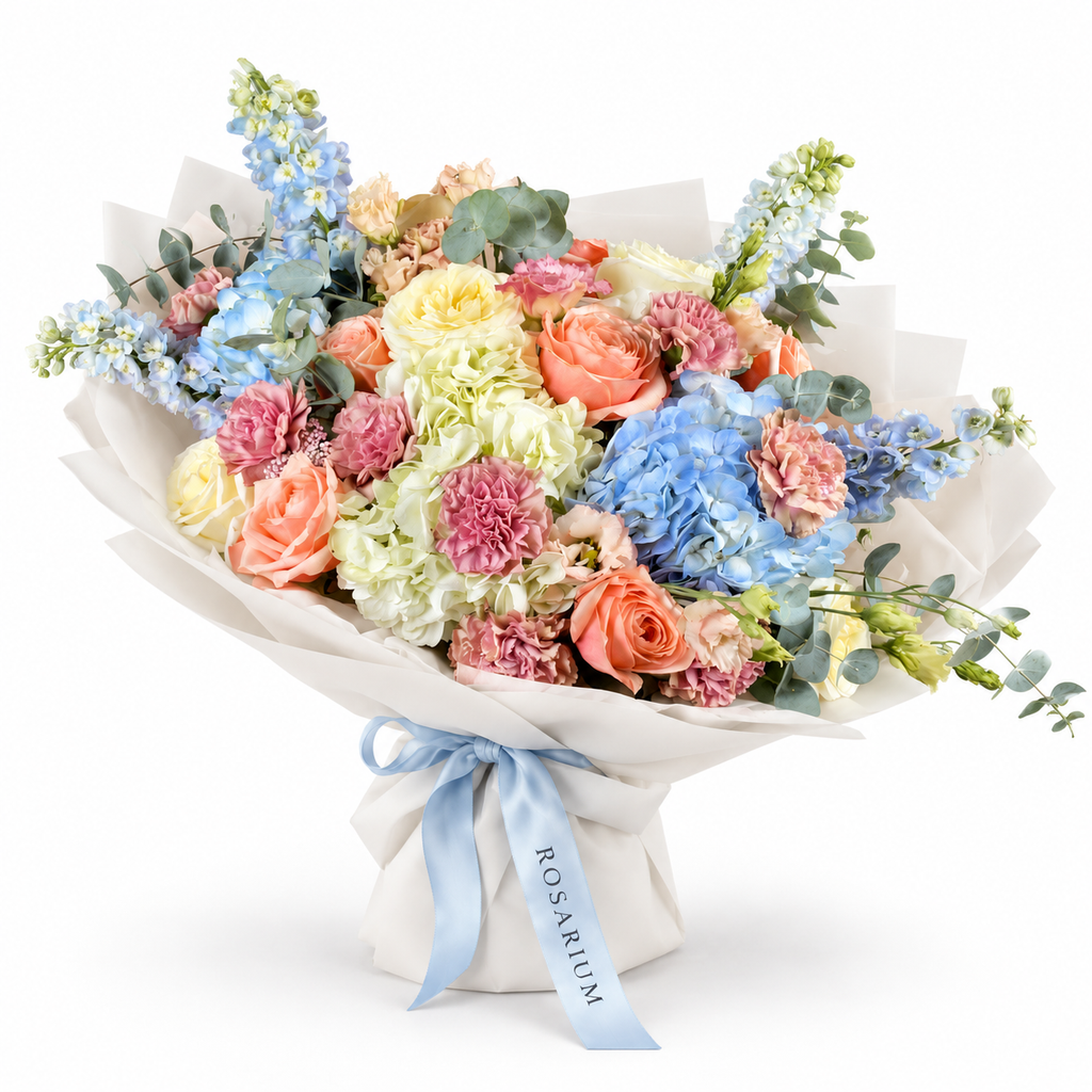 Spring with a Twist: blue and white hydrangea, peach roses and pink carnations in off-white wrapping