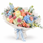 Spring with a Twist: blue and white hydrangea, peach roses and pink carnations in off-white wrapping