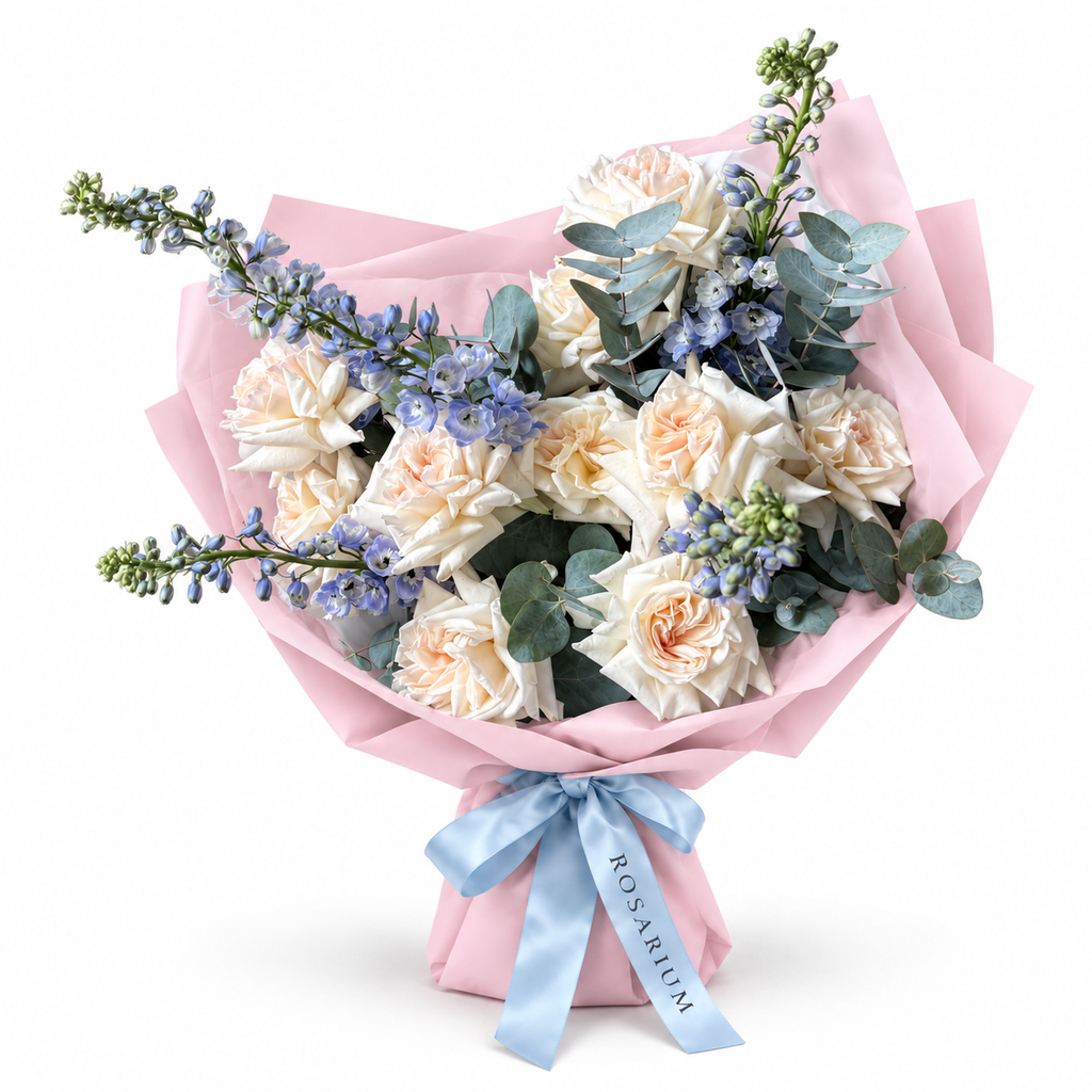 White on Ice: cream roses, blue delphinium and eucalyptus in light pink wrapping