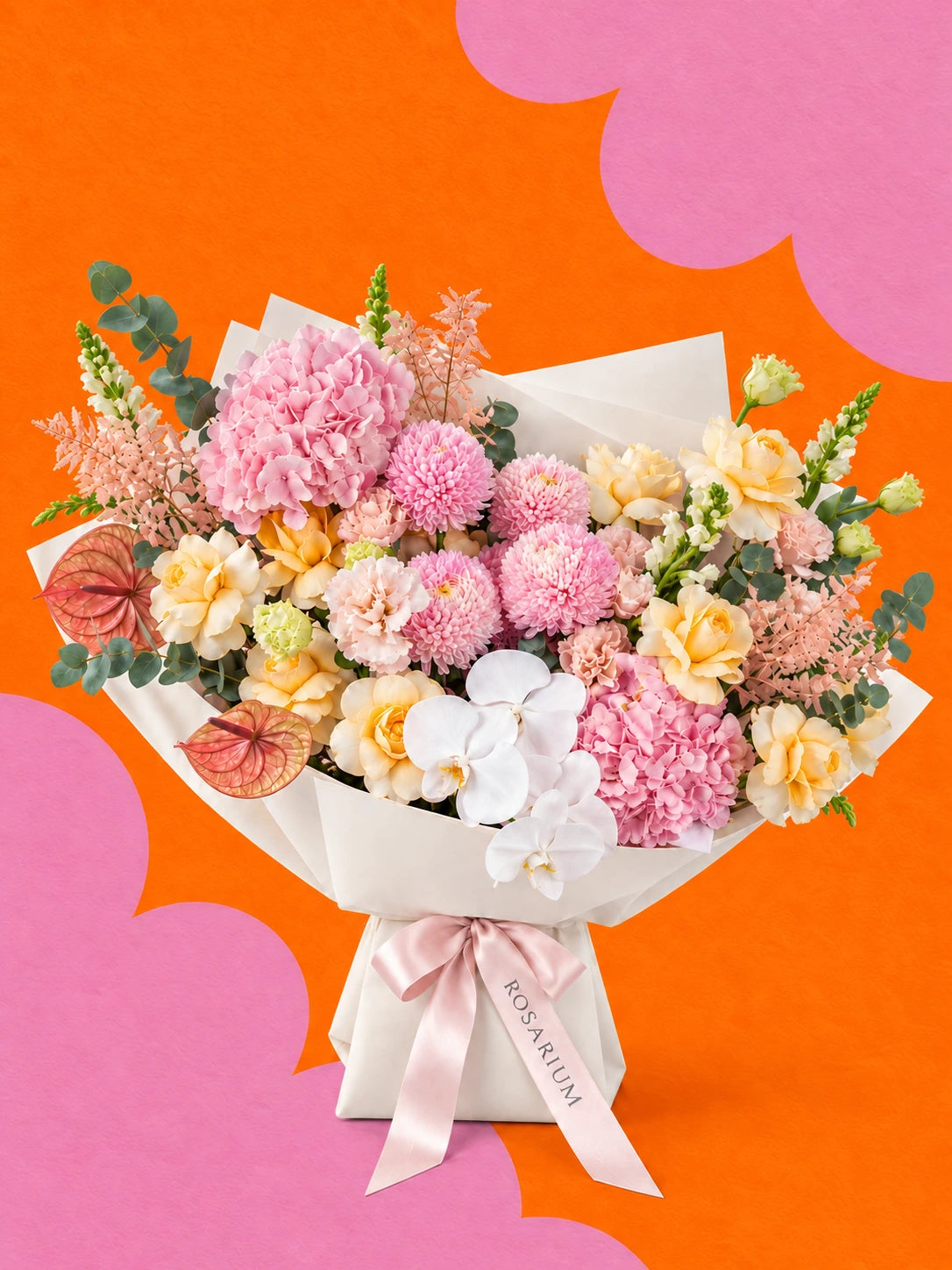 A bouquet of anthuriums, orchids and roses in shades of pink, yellow, white and peach, wrapped in ivory paper.